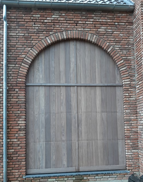 Afrormosia houten sectionale garagepoort geplaatst door schrijnwerker Bongaerts D. in Neeroeteren