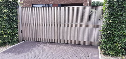 Padouk houten schuifpoort geplaatst door schrijnwerker Bongaerts D. in Ellikom